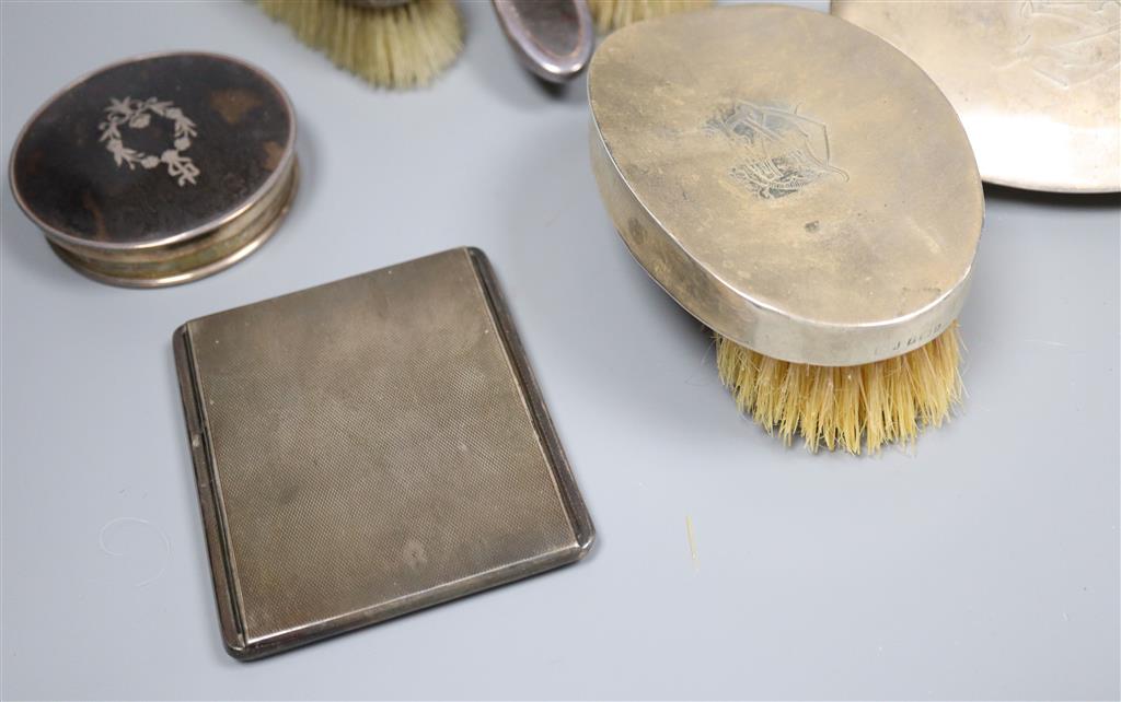 A George V silver cigarette case, five various silver backed brushes and two silver mounted jar tops.